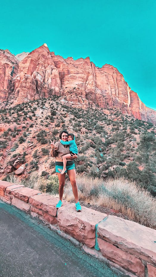 A social media influencer and her little girl posing for a picture at a canyon.