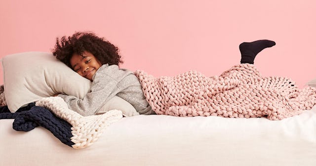 A curly-haired kid enjoying a night’s sleep under a kids weighted blanket