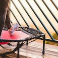 A red and black fitness trampoline on a balcony
