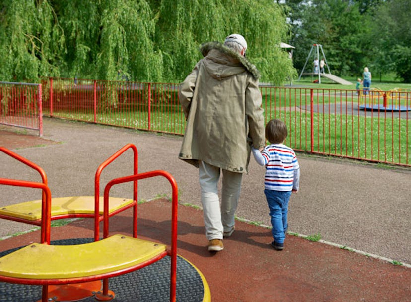 A kid walking with his grandparent in the park