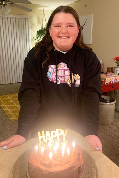 Melanie Hall's daughter in a black hoodie smiling in front of a birthday cake