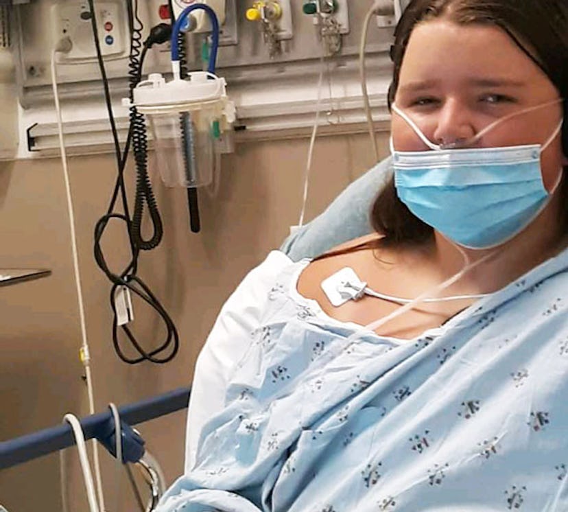 Melanie Hall's daughter in a blue hospital gown in bed due to not getting vaccinated for COVID