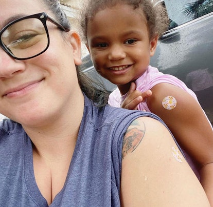  Lindsay Poveromo-Joly smiling with her daughter, both showing their vaccine spot covered with a ban...