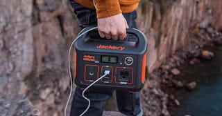 A man holding a generator while camping