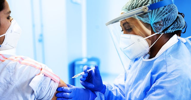A doctor holding a vaccine injection near a patient's arm