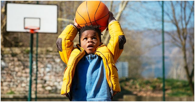 A boy playing with a basketball like an athlete