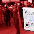 People protesting and a sign in focus that says vaccine mandates are violating rights