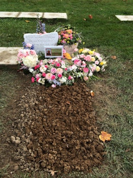 A grave spot of a baby girl that lost her life early, with flowers and pictures on it.