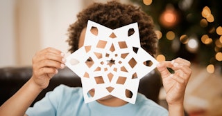 Child holding cut-out snowflake — snowflake coloring pages