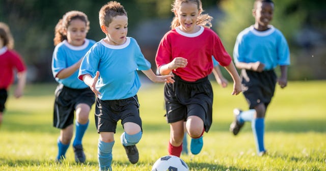 Group of kids playing soccer — sports motivational quotes.