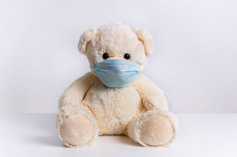 A white teddy bear with a COVID-19 mask over his face representing the Pandemic