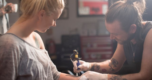 Woman getting tattoo — dinosaur tattoos.