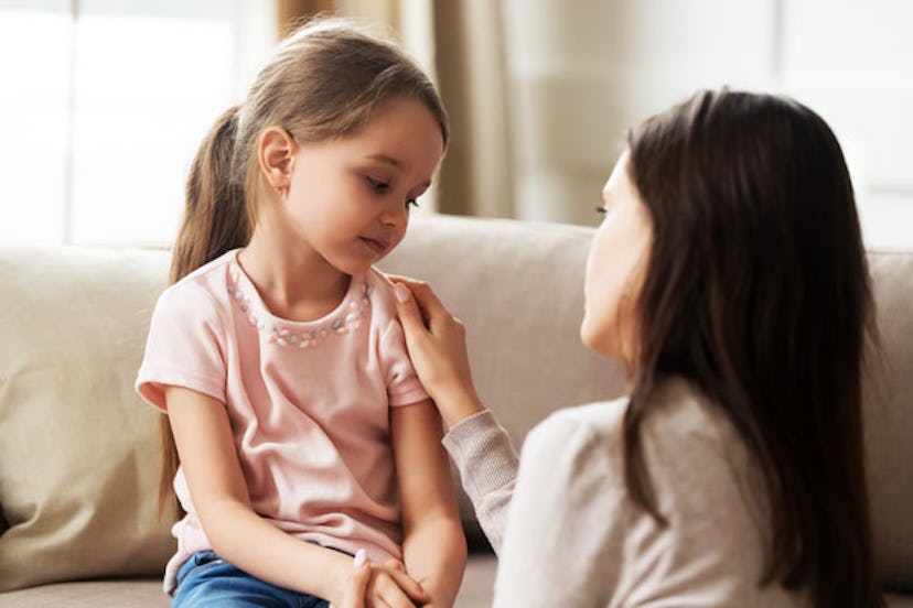 A worried little girl talking to her mom.