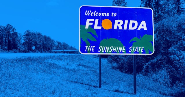 "Welcome to Florida, the sunshine state" sign in blue on the road