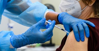 A doctor vaccinating a person with a COVID-19 booster shot