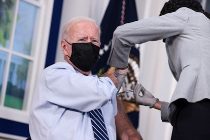 A doctor vaccinating Joe Biden with a COVID-19 booster shot