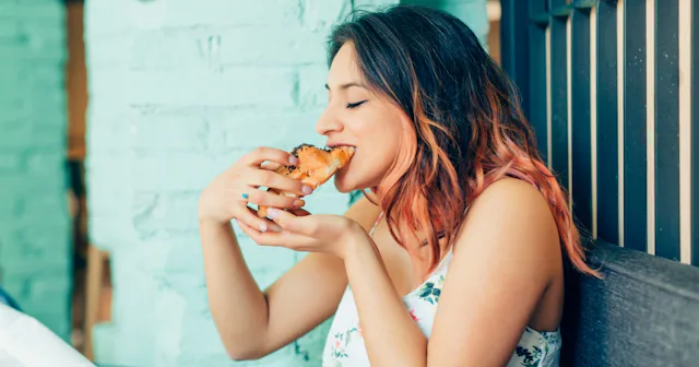 Woman eating croissant — words to describe food.