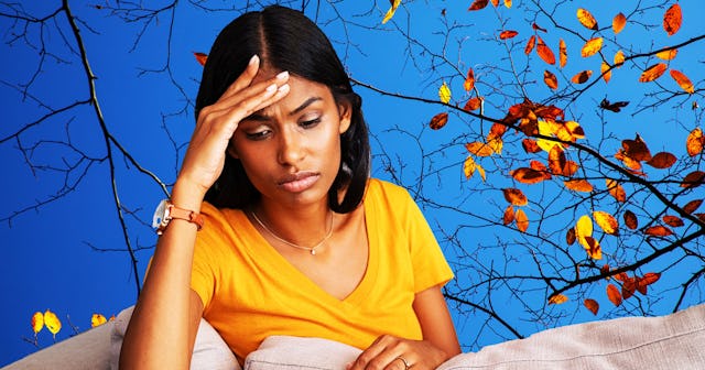 A woman in a yellow T-shirt sitting on her couch, her head resting on the palm of her hand, looking ...