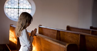 Little girl praying in church 