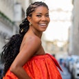 Gabrielle Union smiling in a red sleeveless dress 