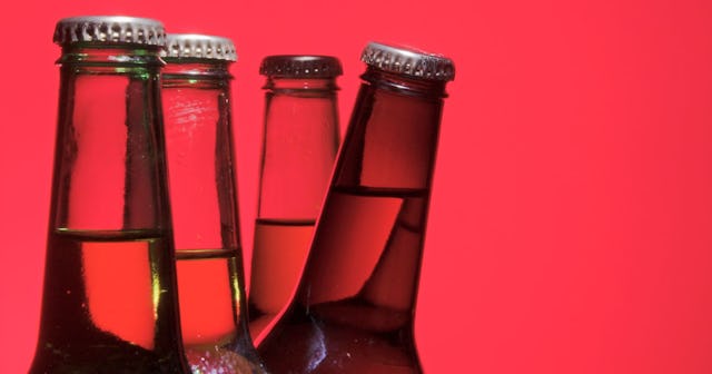 Four glass beer bottles and a red background