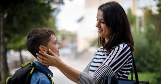 A mom holding her hands on her son's face while talking about mental health