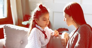 A mother and a daughter sitting on a couch and talking