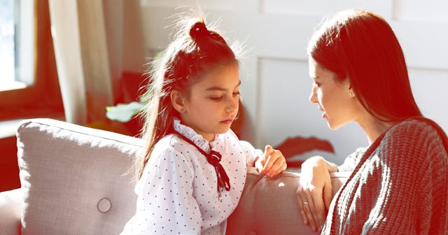 A mother and a daughter sitting on a couch and talking