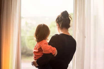 Woman Holding A Child And Looking Out The Window
