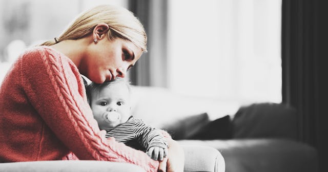 A woman holding a child in her lap and leaning her head on it while being afraid of being alone with...