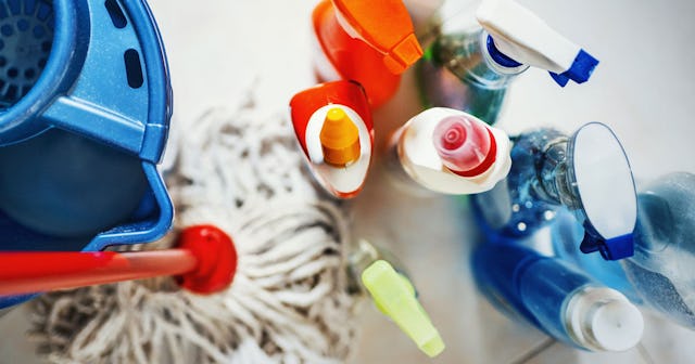 Cleaning supplies next to a mop and a blue bucket