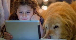 Girl watching tablet with her dog — dog movies.