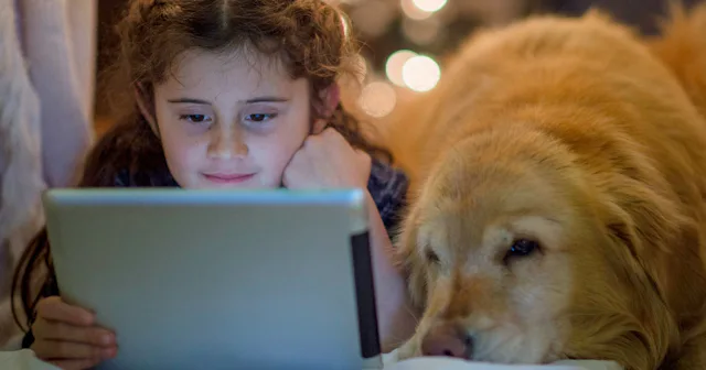 Girl watching tablet with her dog — dog movies.