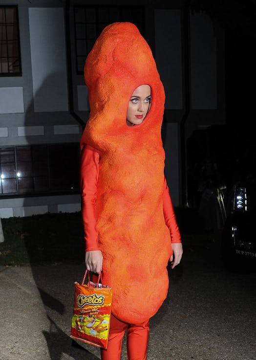 Katy Perry dresses as an orange Cheeto carrying a Cheetos bag