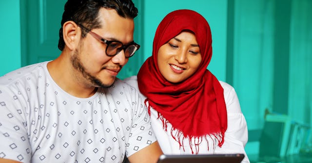A couple planning a holiday trip for 2021 on their tablet