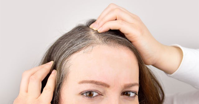 Woman looking at her gray hair 