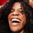 Woman with curly hair laughing at gross stuff with hands on her head 