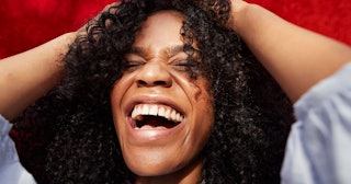 Woman with curly hair laughing at gross stuff with hands on her head 
