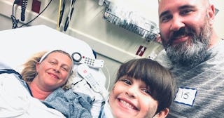 Lindsay Wolf, lying in a hospital bed after her trauma response, with her husband and son next to he...