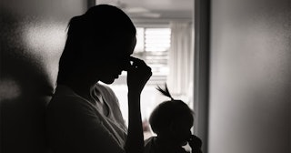 A mom in a hallway with her daughter in black and white
