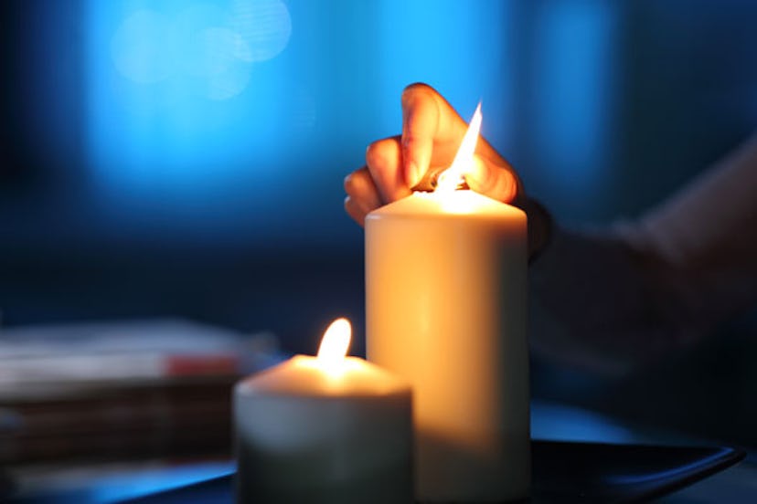 Woman lights two white candles