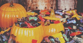 Huge amount of Halloween candy spread around and inside plastic pumpkins