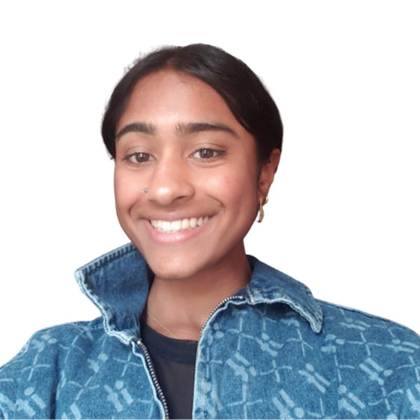  Abinaya Dinesh in a denim zip-up jacket and a black shirt, smiling from ear to ear.