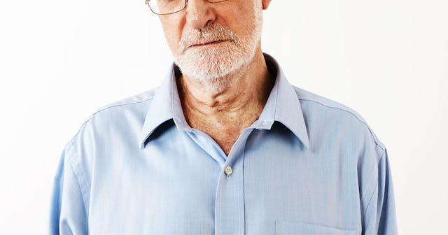 A man, who is part of the boomer generation, wearing a light blue shirt and looking unsatisfied