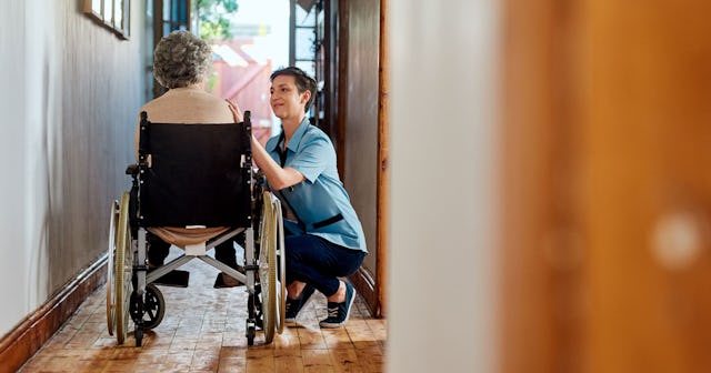 A woman helping her mother-in-law in a wheelchair as her primary caregiver.