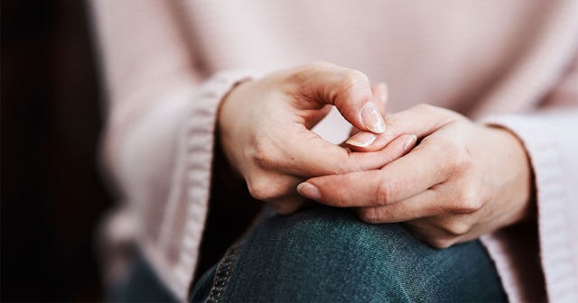 A woman with borderline personality disorder holding her hands on crossed legs 