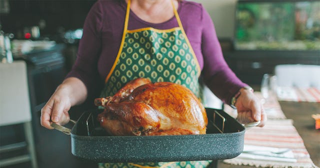 A lady serving a baked turkey on Thanksgiving