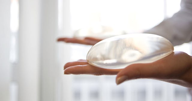 A plastic surgeon holding breast implants in her hands