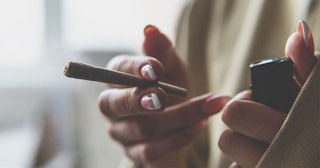 A woman holding a joint and a lighter in her hands