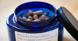 A blue plastic bottle of placenta encapsulation pills